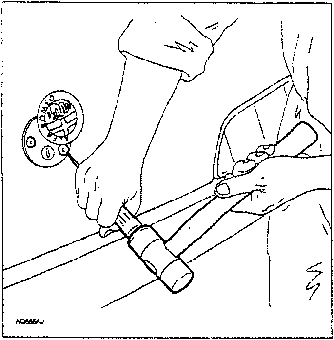 Person using a tool to tighten or loosen a screw on a car part.