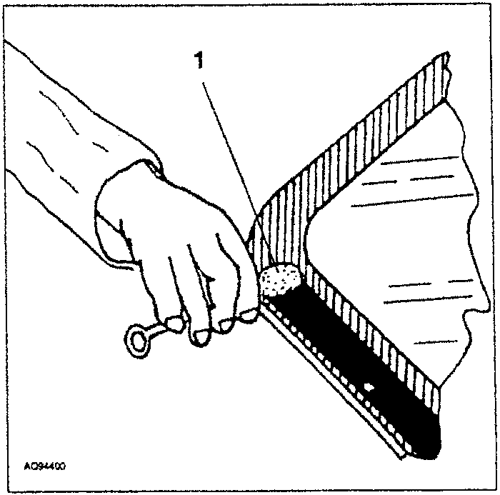 Hand applying primer to the edge of a rear screen glass panel using a tool.