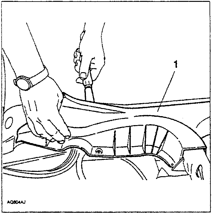 Hand using tool to remove wheelhouse trim
