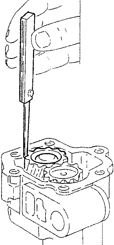 Hand using a tool to measure play inside an oil pump casing with gears visible.