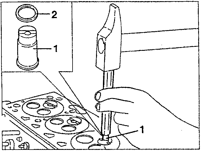 Illustration showing a hand using a punch to remove a component from a cylinder head.