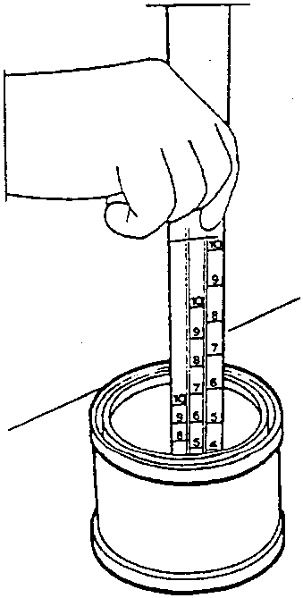 Hand holding a rod-scale in a paint can to measure the thinning