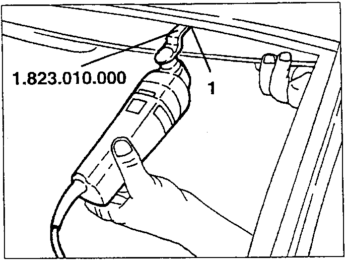 Using electric shears to cut sealant on lower edge of windscreen.