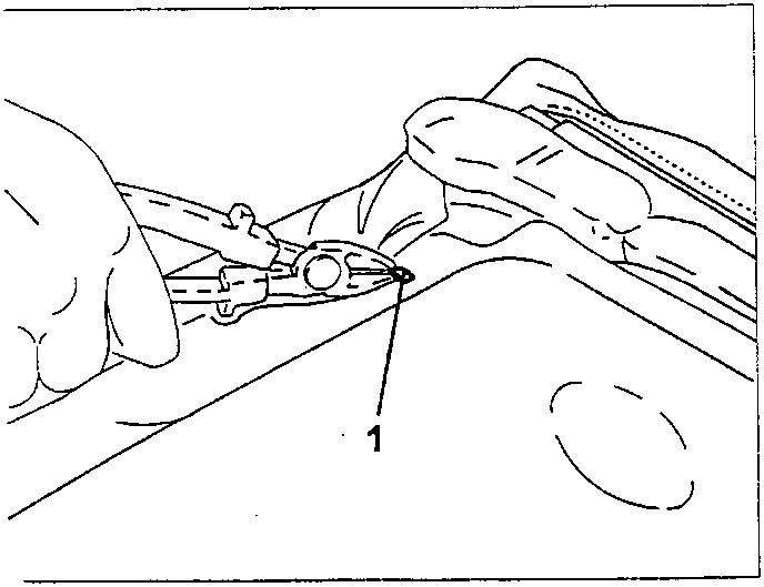 Hand using pliers to cut a metal point (labeled 1) attached to upholstery.