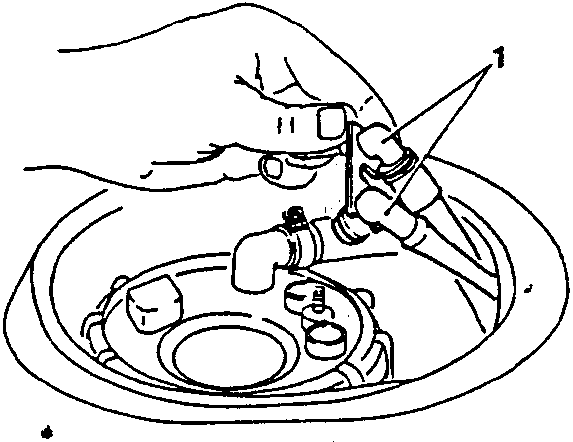 Hand removing a hose from a fuel tank component
