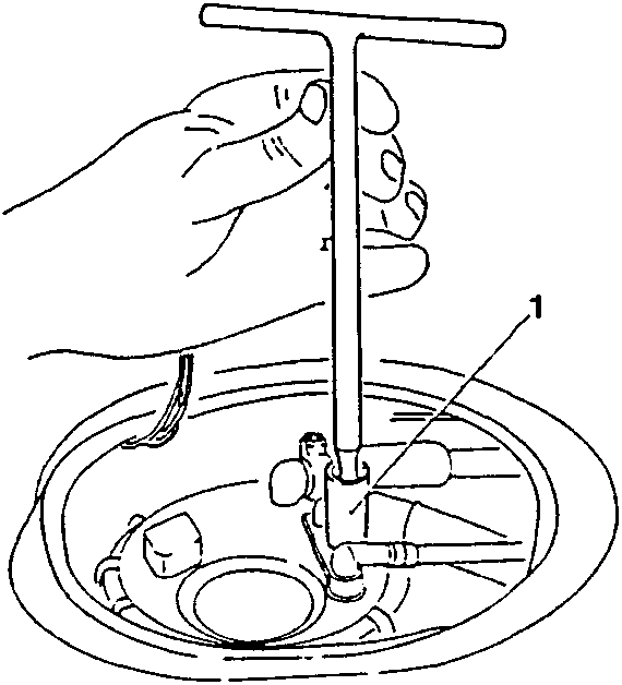 Hand using a T-handle wrench to loosen a nut on a fuel tank component