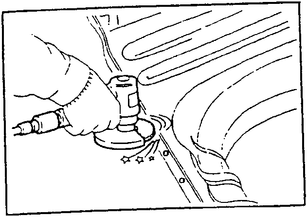 Hand holding a disk sander grinding a metal surface near a weld point.