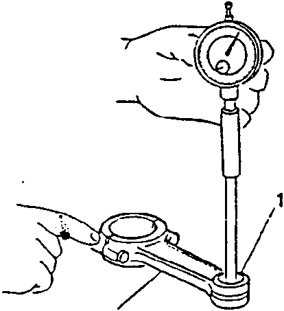 Hand using a dial indicator to measure the diameter of a rod small end bushing hole.