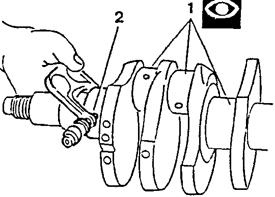 Crankshaft with hand holding tool near journal marked 1 and 2