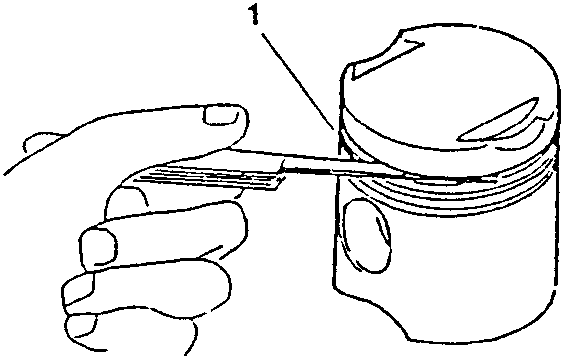 Hand inserting a feeler gauge into the gap of a piston ring inside a cylinder liner.