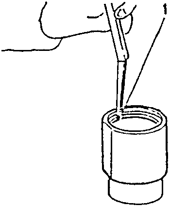 Hand using a tool to insert a piston ring into a cylinder liner.