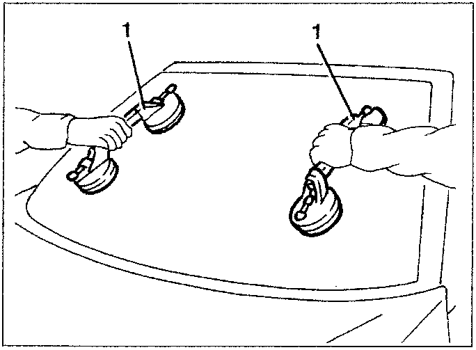 Two hands using suction cups to lift a windshield from its frame