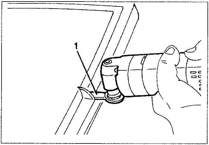 Hand using a tool to scrape off material from the edge of a windshield