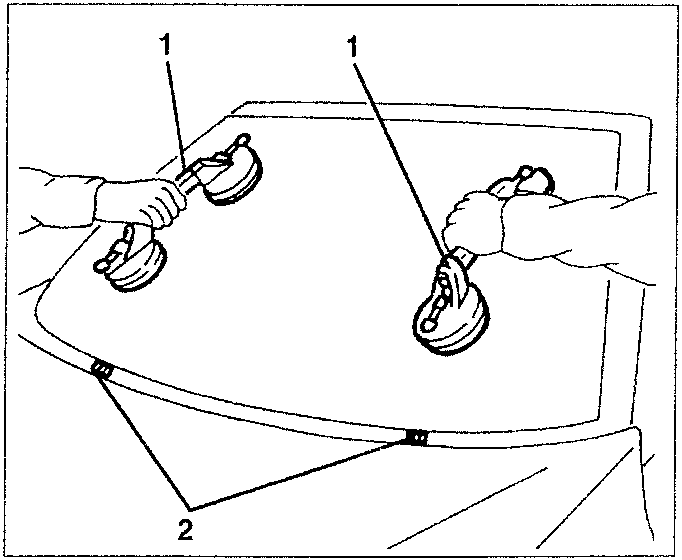 Two hands using suction cups to lower a windshield into its frame