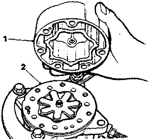 Cylinder head being positioned on cylinder block with hand holding it.