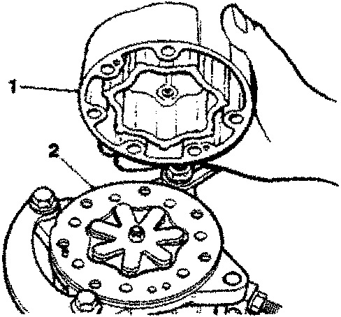 Cylinder head being positioned on cylinder block with hand holding it.