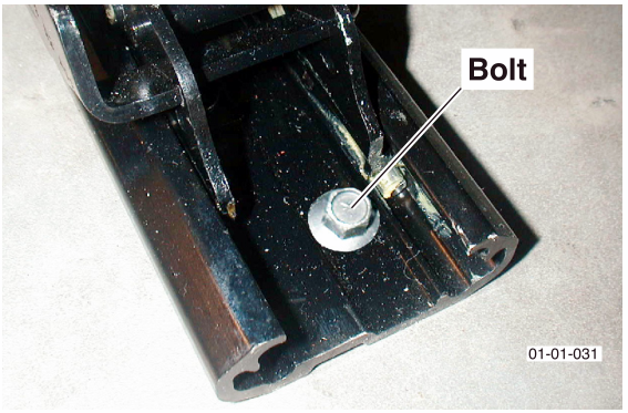 Close-up photograph of a bolt securing the rear seat rail to the vehicle floor pan.