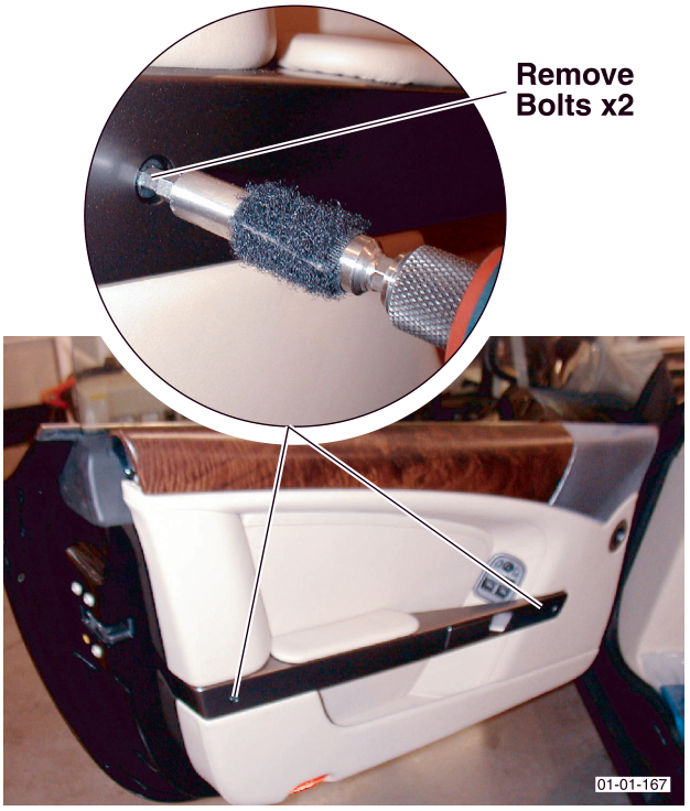 Close-up view of a tool removing bolts from the door handle assembly