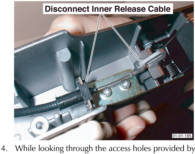 Close-up of hand disconnecting inner release cable from mechanism