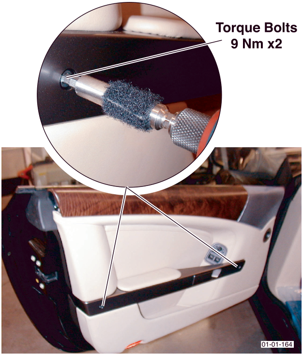 Image showing a torque wrench tightening bolts on the door handle with callout text 'Torque Bolts 9 Nm x2'