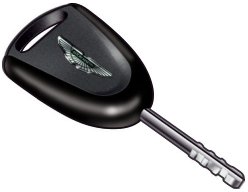 A black Aston Martin vehicle key fob with a metal key blade extending from the bottom.