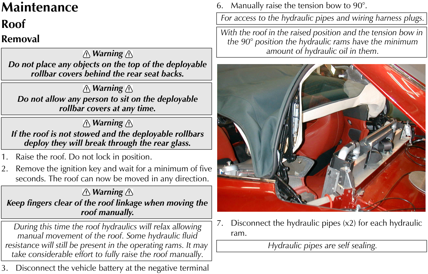 Interior view of the car showing the raised tonneau cover and the hydraulic ram mechanism located behind the rear seats.