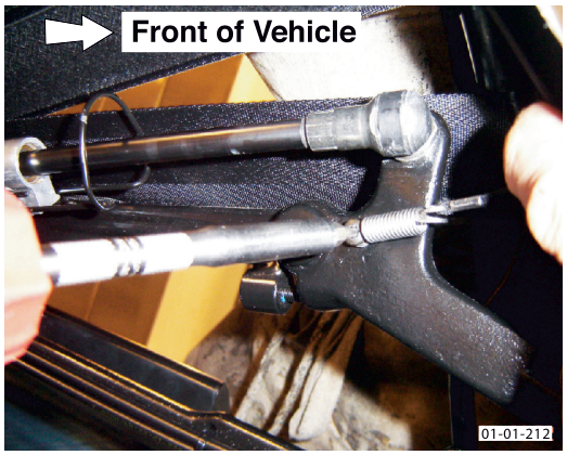 A close-up view of the window tension cord and spring mechanism, with an arrow indicating 'Front of Vehicle'.