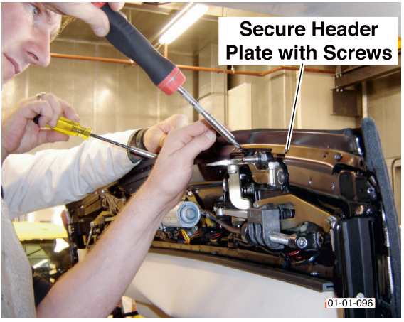 A person using screwdrivers to secure the header plate with screws. Label reads Secure Header Plate with Screws.