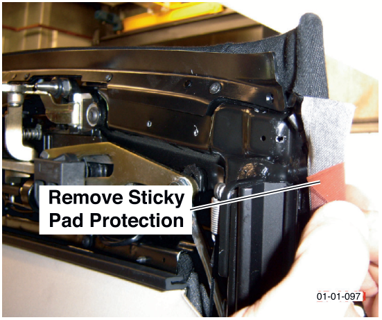 A hand removing the protective backing from a sticky pad on the roof material. Label reads Remove Sticky Pad Protection.