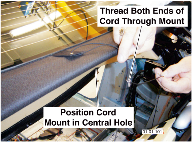 Hands positioning a cord mount in the central hole and threading both ends of the cord through the mount.