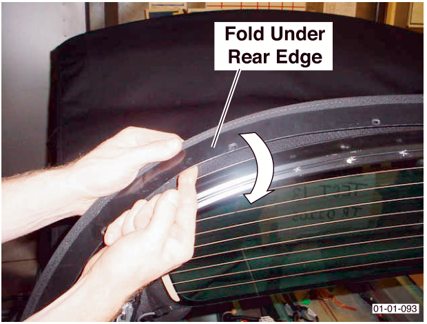Hands folding the edge of the roof material under the rear edge of the tension bow.