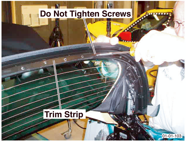 A trim strip being installed along the rear edge of the roof mechanism, with a label indicating 'Do Not Tighten Screws'.