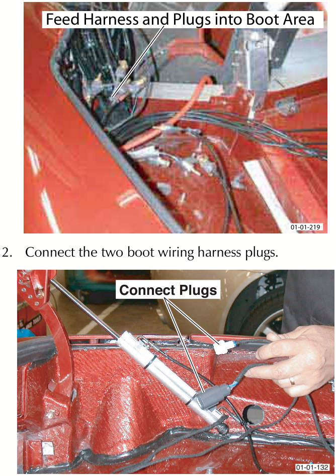 Hydraulic pipes and wiring harnesses being fed into the red painted boot area of the vehicle.