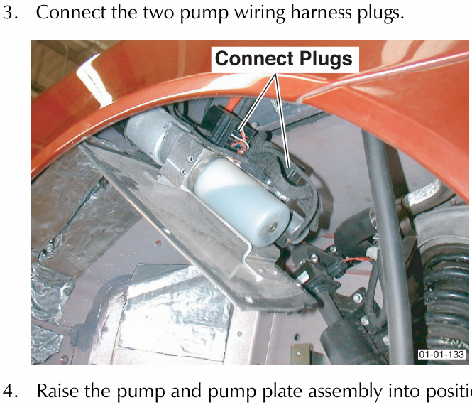 Two wiring harness plugs connected to a component near the rear suspension and shock absorber.