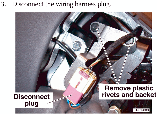 Close-up view under the seat showing a wiring harness plug being disconnected, with plastic rivets and a bracket visible.