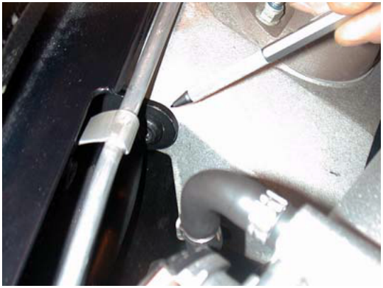 A close-up view of a tool marking or working near a component in the engine bay area.