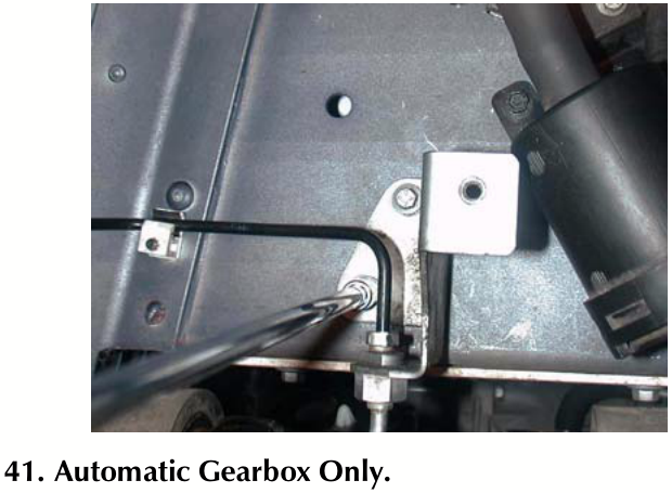 View of rear brake pipe bracket and mounting hardware under vehicle chassis