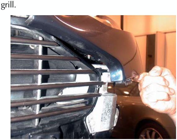 Photograph showing a hand disconnecting a wing component as the vehicle is raised