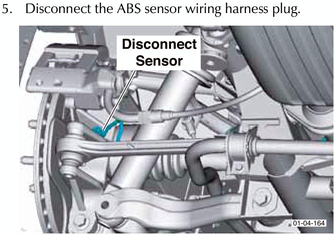 View of the ABS sensor wiring harness plug being disconnected