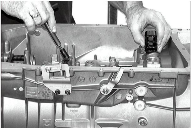 Hands using a tool to remove seals from the Mechatronik unit on the transmission
