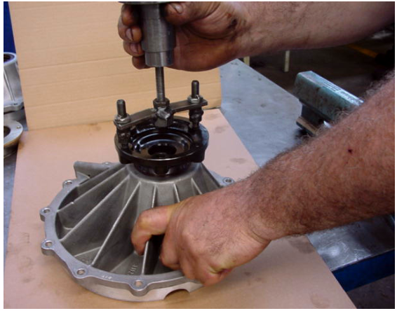 Photo of a mechanic using a slide hammer to remove the differential housing cover