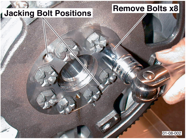 Flywheel with jacking bolt positions indicated and text 'Remove Bolts x8'
