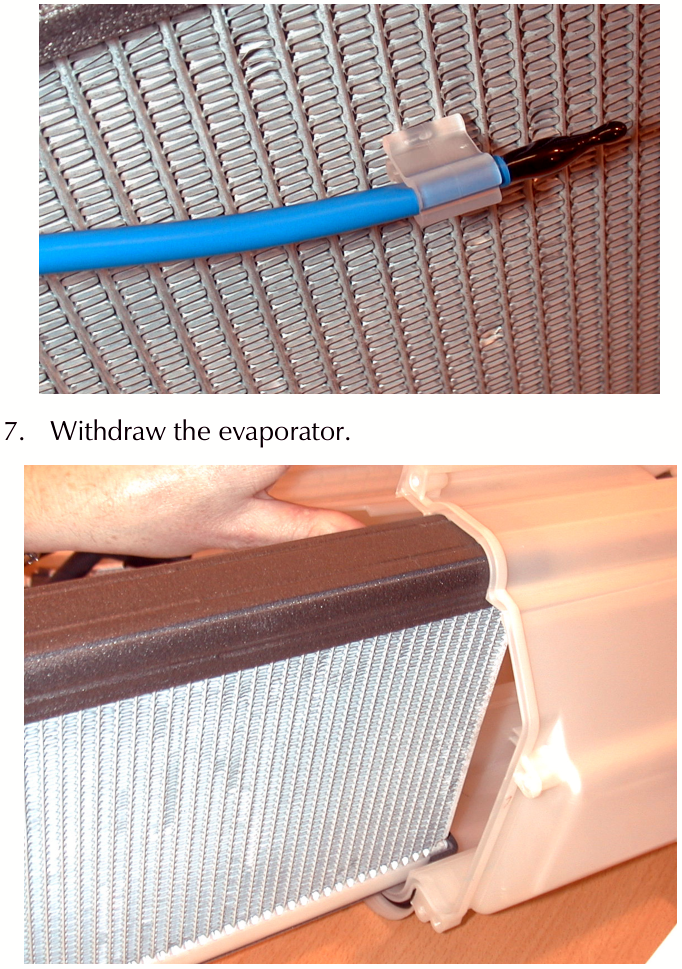 A close-up photograph of a blue tube with a black sensor element attached to the fins of an evaporator core using a white plastic clip.