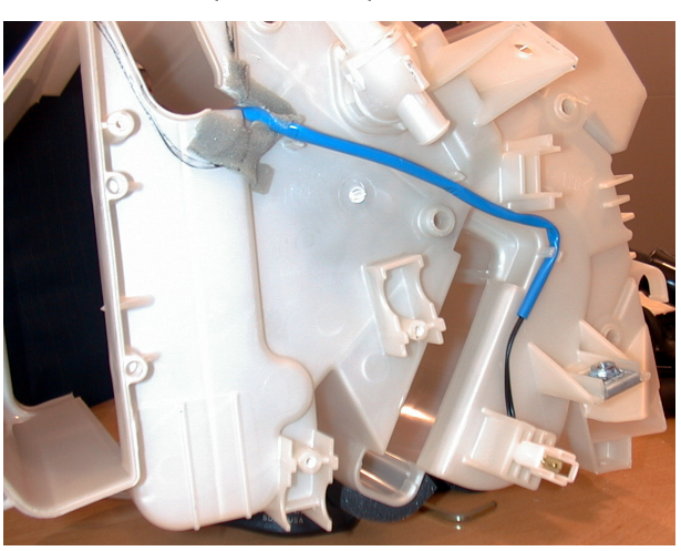 Photograph showing the internal components of an A/C unit with a blue tube visible