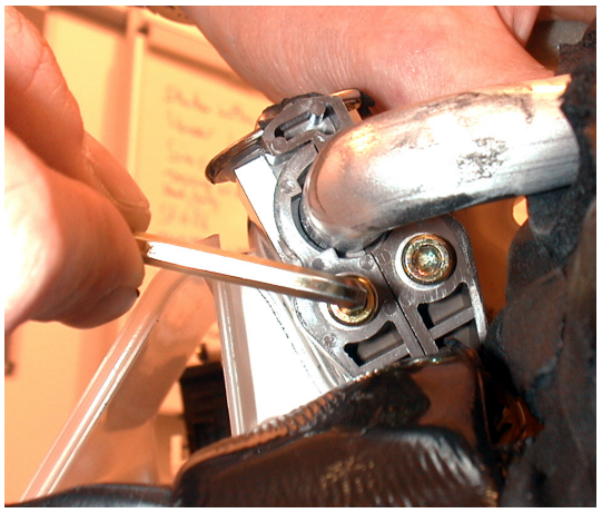 Photo of hands removing screws from the A/C pipes clamp on the expansion valve
