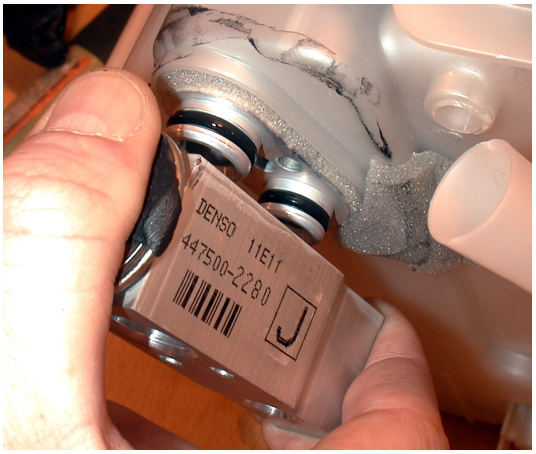 Photo of the expansion valve being withdrawn from its mounting point