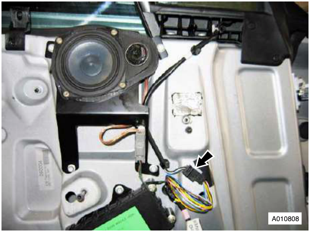 Interior view of door panel showing speaker, wiring harness with multiplug connector, and mounting points.