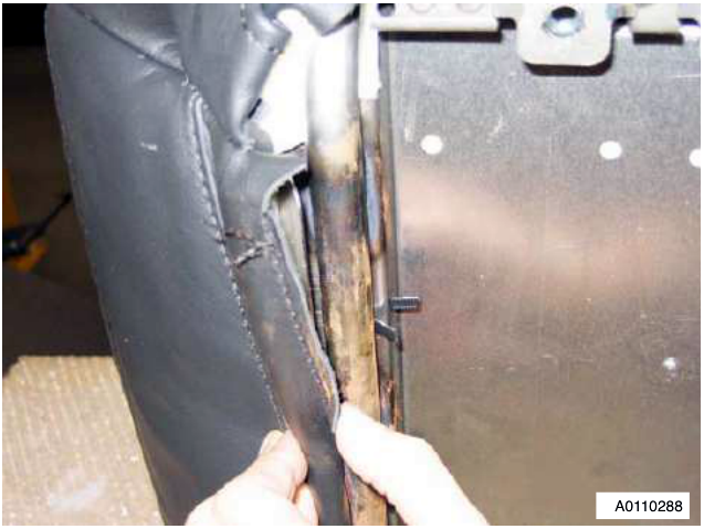 Close-up of the seat cover being released from the cushion frame assembly