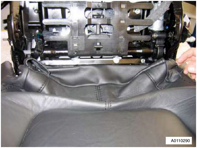 Close-up of the seat cushion cover being pulled from between the squab and cushion frames