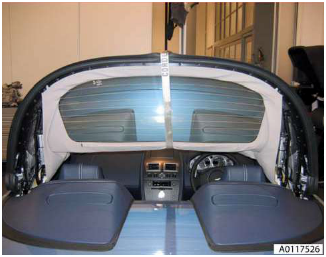 Interior view of the convertible roof in a halfway position, supported by straps across the rear window area